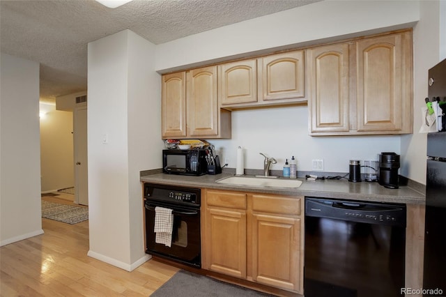 kitchen with light brown cabinetry, sink, a textured ceiling, light hardwood / wood-style floors, and black appliances