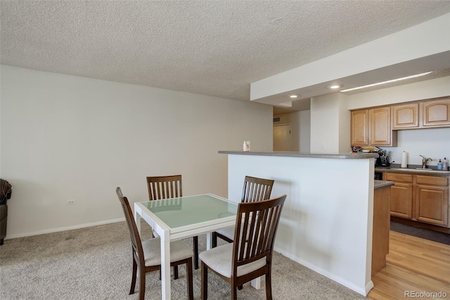 carpeted dining space featuring wet bar and a textured ceiling