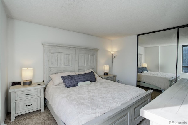 bedroom featuring light carpet and a textured ceiling