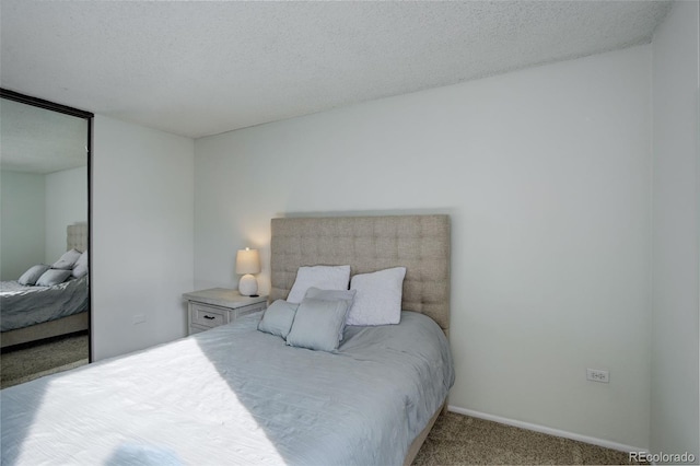 carpeted bedroom featuring a closet and a textured ceiling