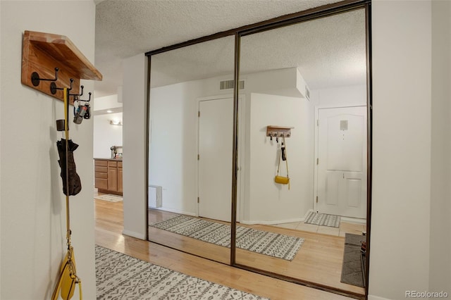 interior space featuring wood-type flooring and a textured ceiling