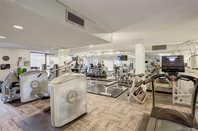 gym featuring light carpet and a textured ceiling