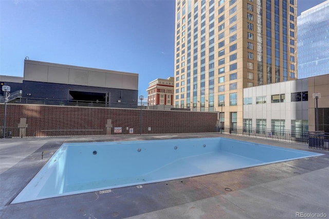 view of swimming pool featuring a hot tub