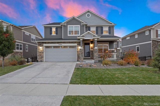 view of front of house featuring a garage, a lawn, and covered porch