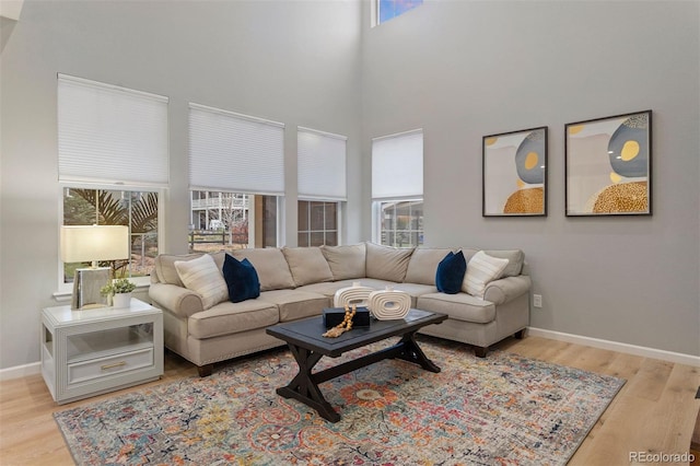 living room with light hardwood / wood-style flooring and a high ceiling