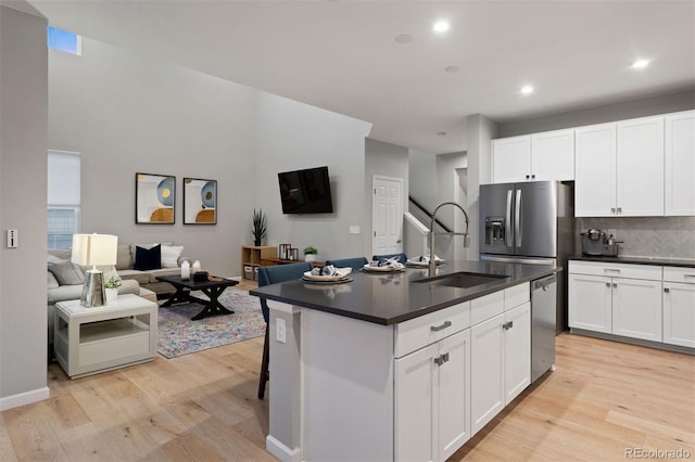 kitchen featuring sink, a center island with sink, white cabinets, and stainless steel appliances