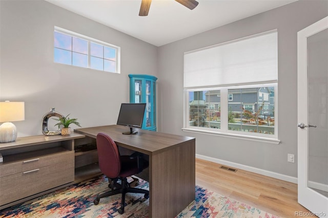 office space with light wood-type flooring, ceiling fan, and a wealth of natural light