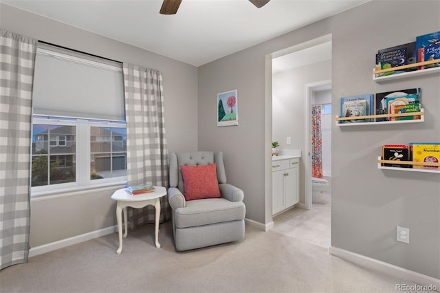 living area with ceiling fan and light colored carpet