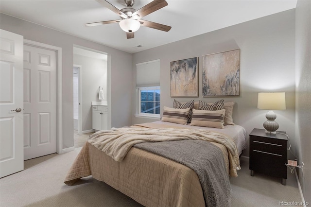 carpeted bedroom with ensuite bath and ceiling fan