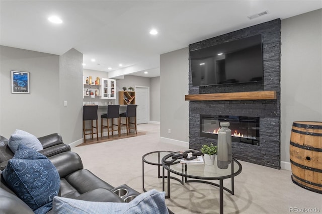 living room with light carpet, bar, and a fireplace