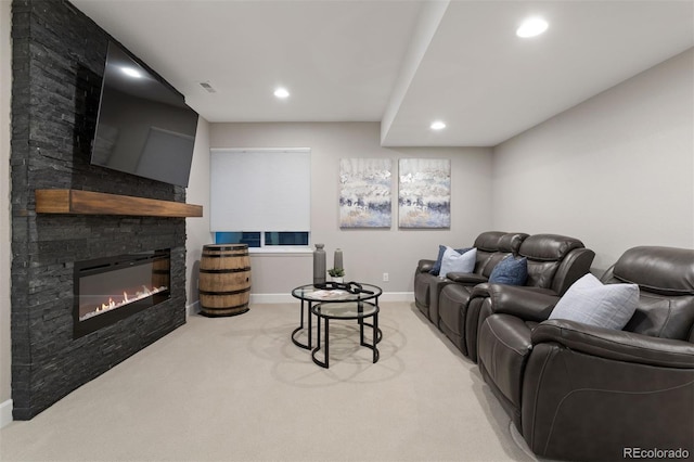 carpeted living room featuring a stone fireplace