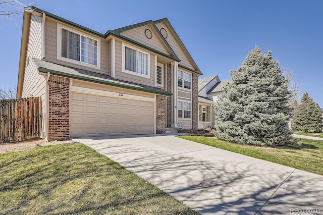 traditional home featuring a garage, fence, driveway, and brick siding