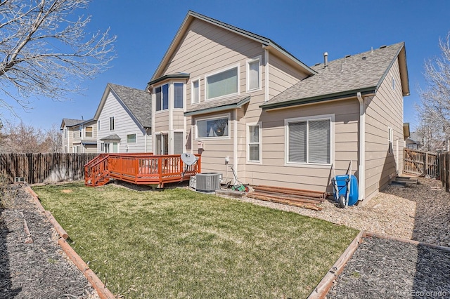 back of property featuring central AC unit, a lawn, a fenced backyard, a wooden deck, and roof with shingles