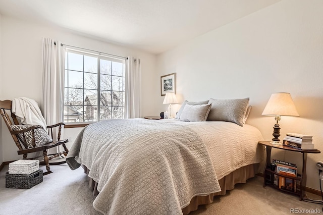 bedroom featuring light colored carpet and baseboards