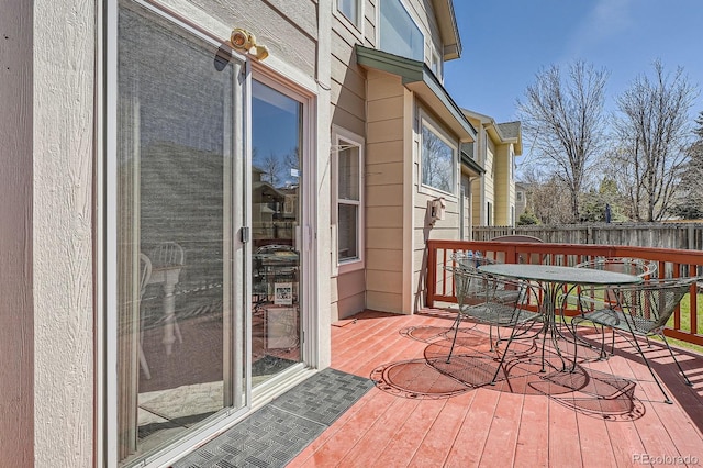 wooden terrace featuring outdoor dining area and fence