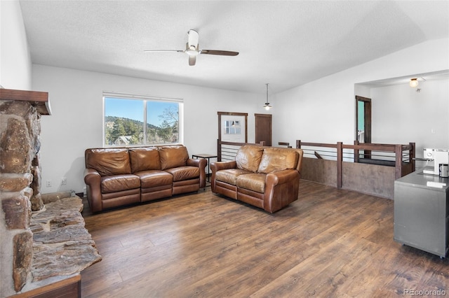 living room featuring a textured ceiling, ceiling fan, dark hardwood / wood-style flooring, and lofted ceiling