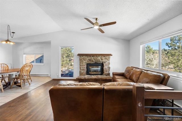 living room with a textured ceiling, vaulted ceiling, ceiling fan, a baseboard radiator, and light hardwood / wood-style flooring