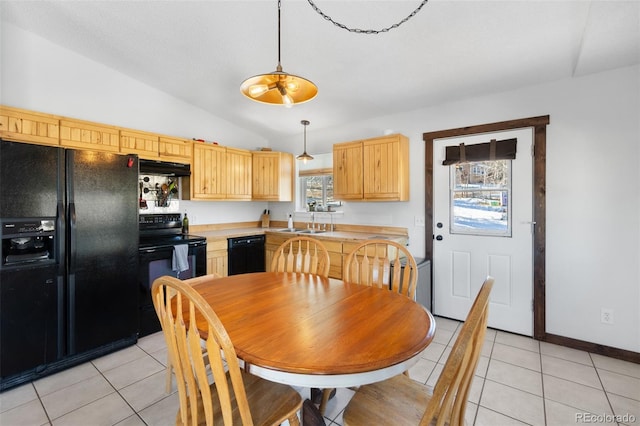 kitchen featuring hanging light fixtures, lofted ceiling, light brown cabinetry, light tile patterned flooring, and black appliances