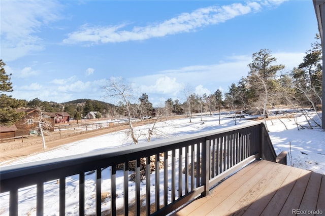 snow covered deck with a mountain view