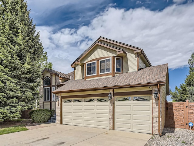 9412 La Quinta Way, Lone Tree, CO 80124 - view of front facade with brick siding, driveway, an attached garage, and fence