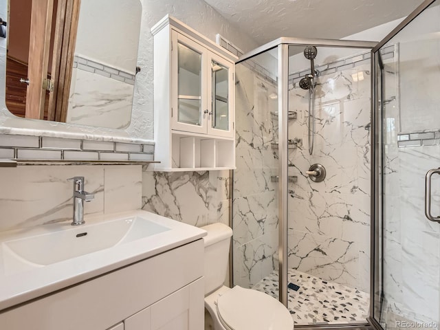 9412 La Quinta Way, Lone Tree, CO 80124 - full bath with a marble finish shower, toilet, tile walls, and vanity