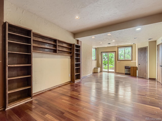 9412 La Quinta Way, Lone Tree, CO 80124 - unfurnished bedroom featuring access to exterior, hardwood / wood-style flooring, a textured ceiling, a textured wall, and recessed lighting