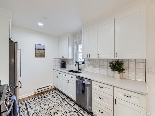 kitchen featuring a baseboard heating unit, sink, white cabinets, and appliances with stainless steel finishes