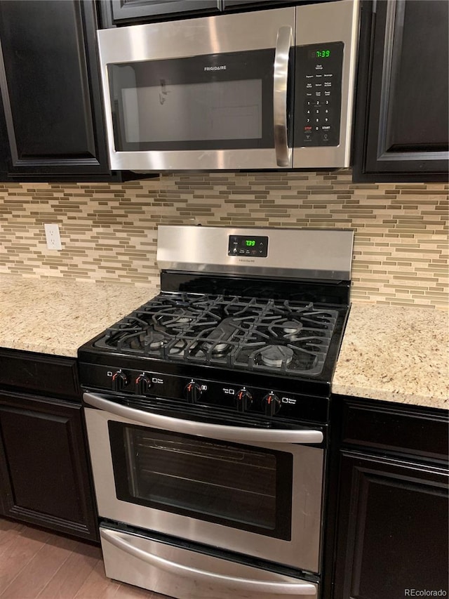 kitchen featuring light stone counters, light hardwood / wood-style flooring, backsplash, and stainless steel appliances