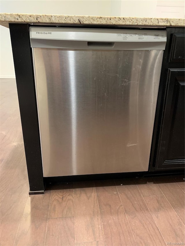 room details with hardwood / wood-style flooring and stainless steel dishwasher