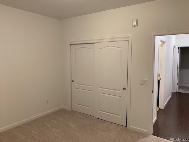 unfurnished bedroom with dark wood-type flooring and a closet