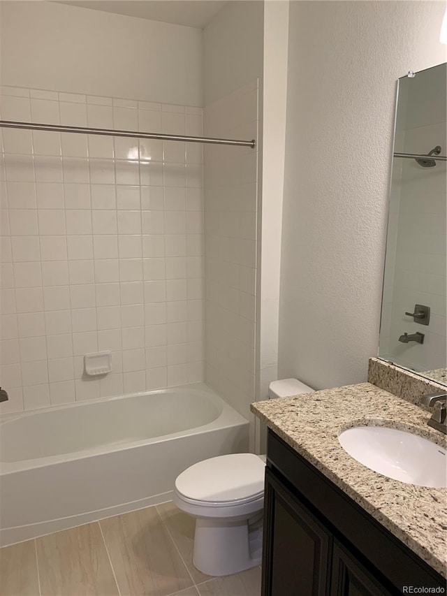 full bathroom with toilet, tiled shower / bath combo, and vanity