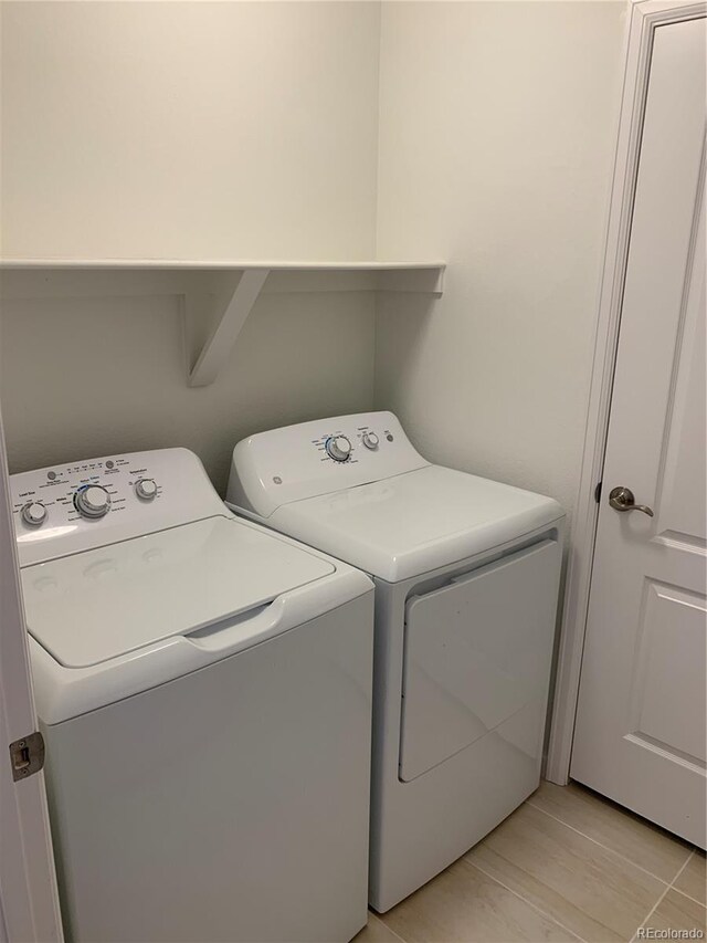 laundry room featuring washer and dryer and light hardwood / wood-style flooring