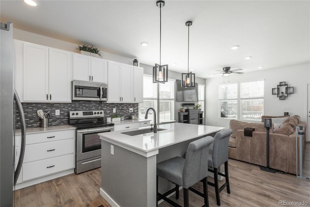 688 N Bersshine Ct, Watkins, CO 80137 - kitchen with appliances with stainless steel finishes, a sink, plenty of natural light, open floor plan, and recessed lighting