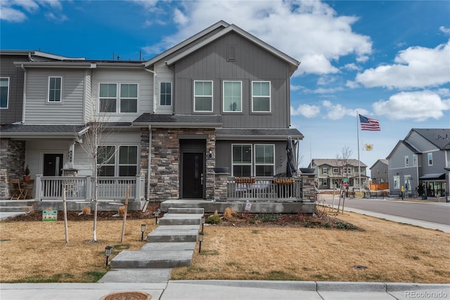 688 N Bersshine Ct, Watkins, CO 80137 - view of property with covered porch, stone siding, a residential view, and board and batten siding