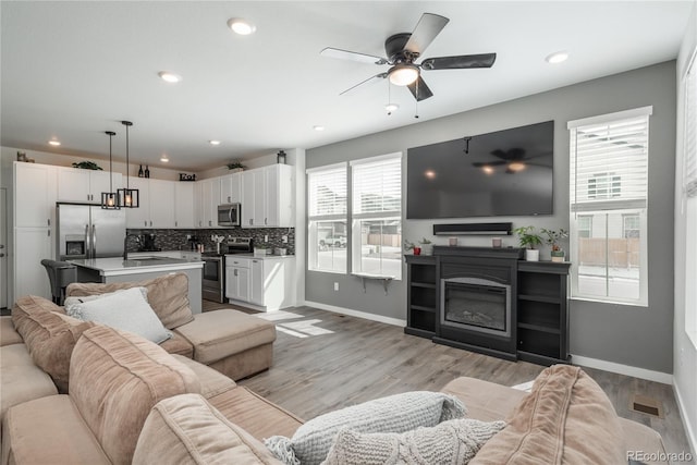 688 N Bersshine Ct, Watkins, CO 80137 - living area featuring a ceiling fan, baseboards, light wood-style flooring, and recessed lighting