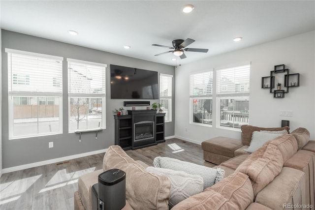 688 N Bersshine Ct, Watkins, CO 80137 - living room with ceiling fan, wood finished floors, baseboards, recessed lighting, and a glass covered fireplace