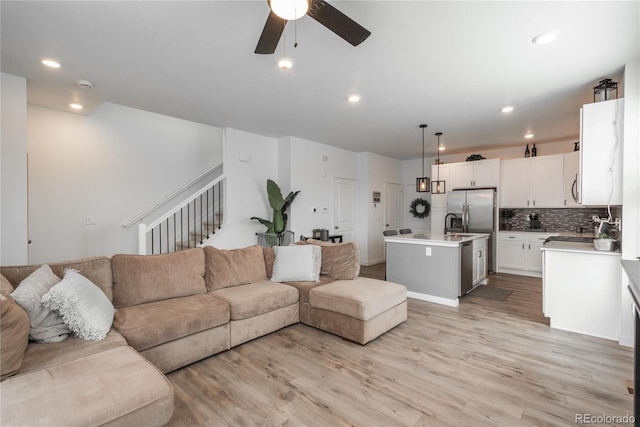 688 N Bersshine Ct, Watkins, CO 80137 - living room featuring a ceiling fan, light wood-type flooring, stairway, and recessed lighting