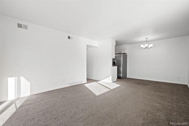 unfurnished living room with a notable chandelier and dark colored carpet