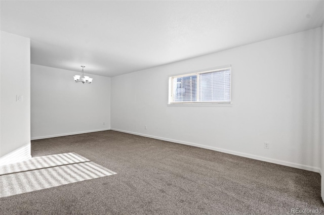 carpeted spare room with a chandelier