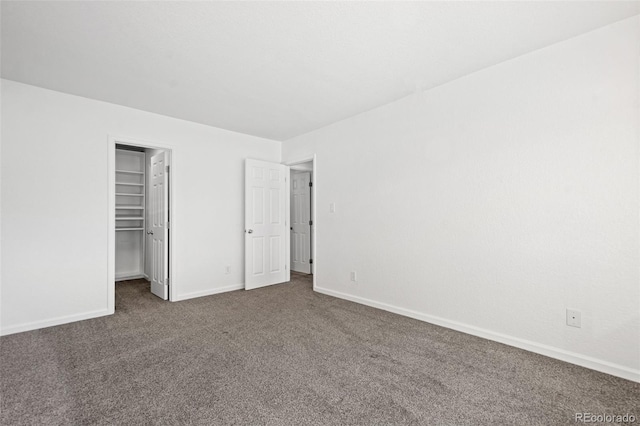 unfurnished bedroom with a closet and dark colored carpet