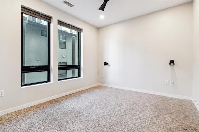 carpeted spare room featuring ceiling fan