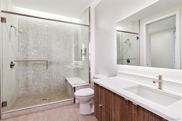 bathroom featuring tile patterned floors, toilet, vanity, and walk in shower