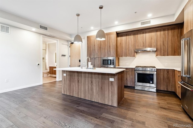 kitchen featuring pendant lighting, dark hardwood / wood-style flooring, an island with sink, high end appliances, and sink