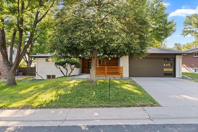 7036 S Apache St, Littleton, CO 80120 - view of property hidden behind natural elements with a garage, concrete driveway, a front yard, and a porch