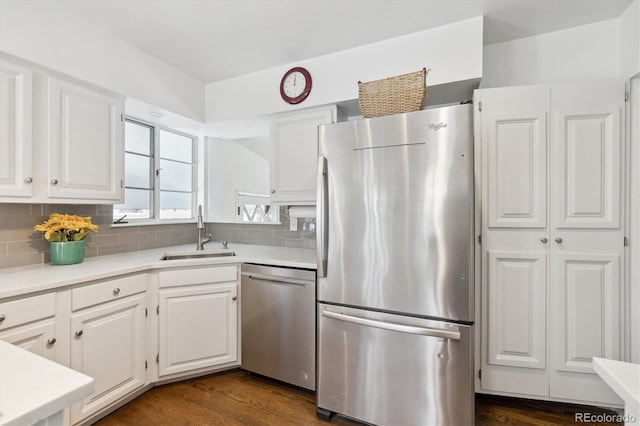 kitchen with sink, backsplash, white cabinetry, and stainless steel appliances