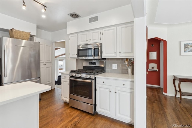 kitchen featuring white cabinetry, decorative backsplash, dark hardwood / wood-style floors, and stainless steel appliances