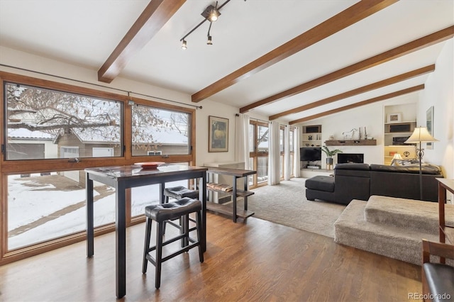 interior space featuring hardwood / wood-style flooring and vaulted ceiling with beams