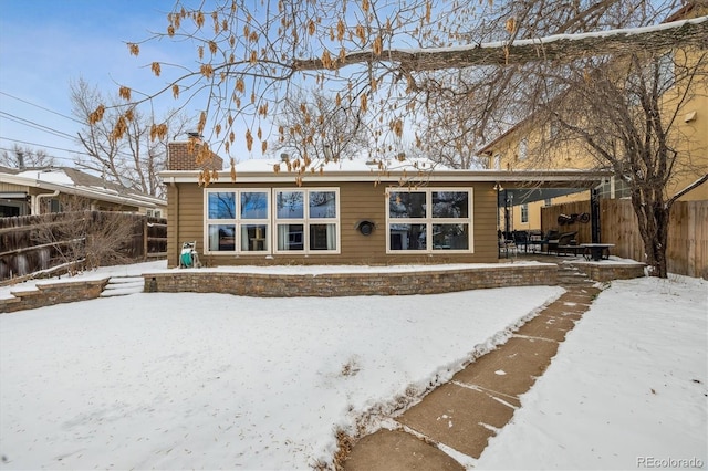 view of snow covered rear of property