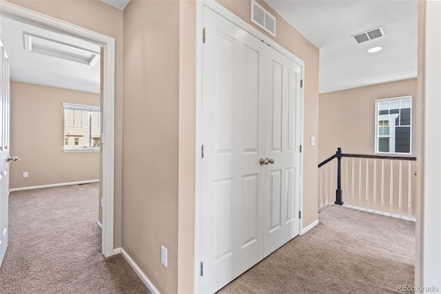 hallway featuring light colored carpet