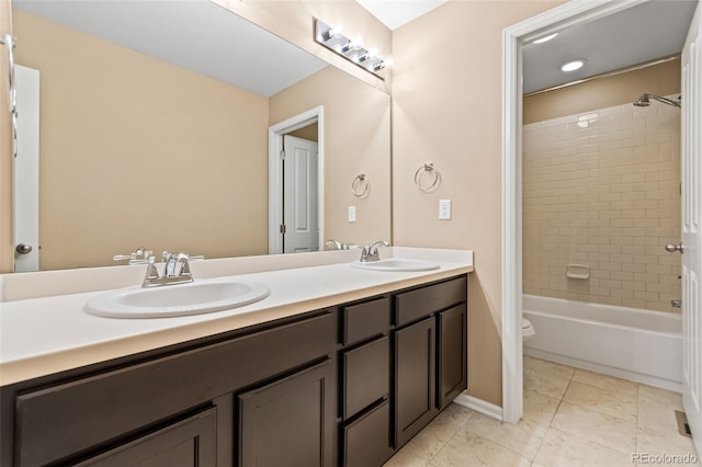 full bathroom featuring tile patterned flooring, vanity, tiled shower / bath, and toilet